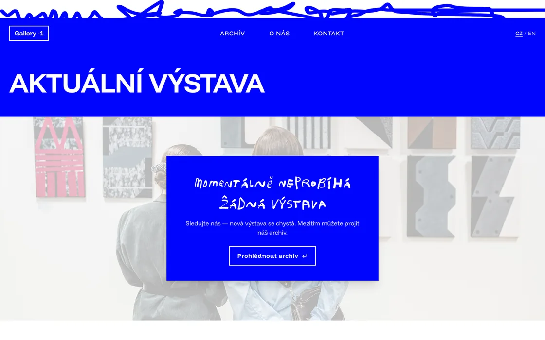 Náhled webu Galerie mínus jedna: sytě modrá titulní plocha s nápisem Aktuální výstava a fotografií z výstavního prostoru.